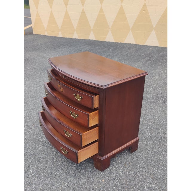Lexington bow front nightstand / commode. Chippendale style with bracket feet and brass drawer pulls. Four drawers in...