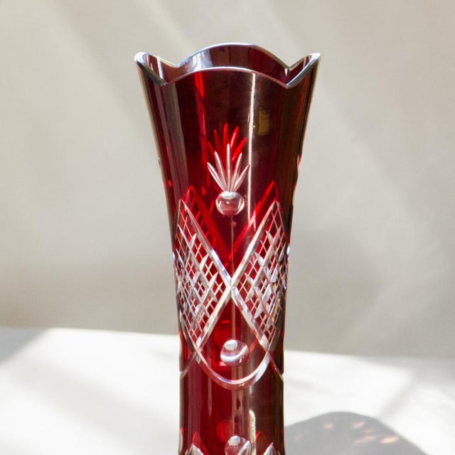 Elegant antique vase in ruby ​​red overlaid Bohemian glass, richly decorated with wheel cutting, circa 1950. Geometric...