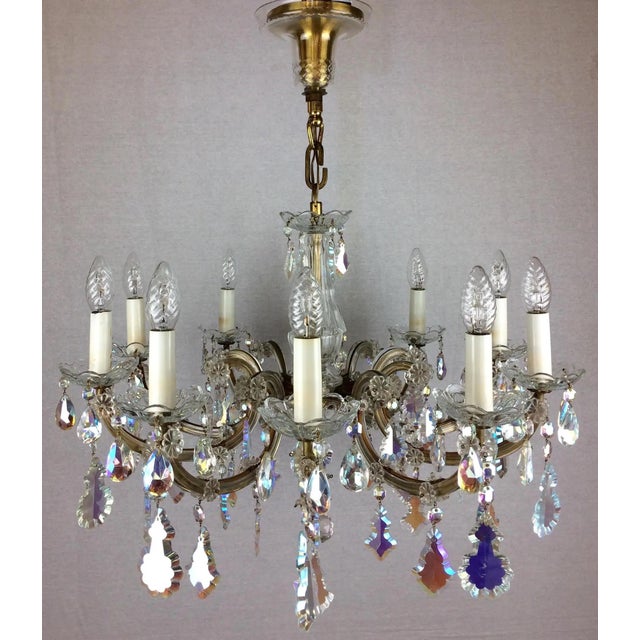 A stunning Maria Theresa 10 arm crystal chandelier fully arranged with colored rock crystals and drops. This antique...