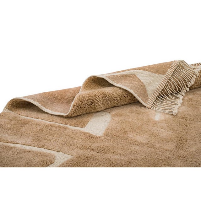 Captivating hand-knotted wool rug in light Mocha mousse, adorned with abstract Ivory shapes. The minimalist design and...