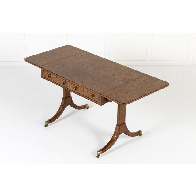 An early 19th century english regency sofa table, veneered throughout in beautifully figured burr elm of a good colour...