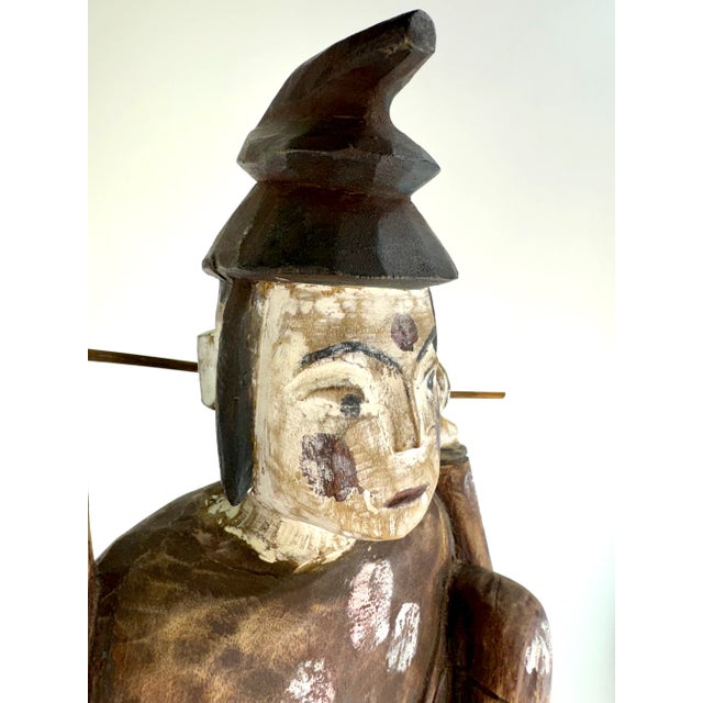 This vintage hand-carved wood sculpture of an Asian fisherman is a distinctive piece that captures traditional...