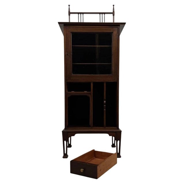 An elegant early 20th-century English display cabinet, finely crafted from mahogany and distinguished by its unusual...