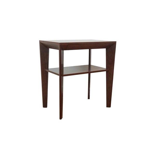 Lovely petite beside table with multi-sided diagonal base. Equipped with discreet mitered pencil drawer with soft-close...