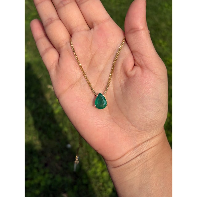 This delicate 3.88 carat pear-cut emerald pendant necklace is crafted in 14K yellow gold. The stone measures about 12.3 x...