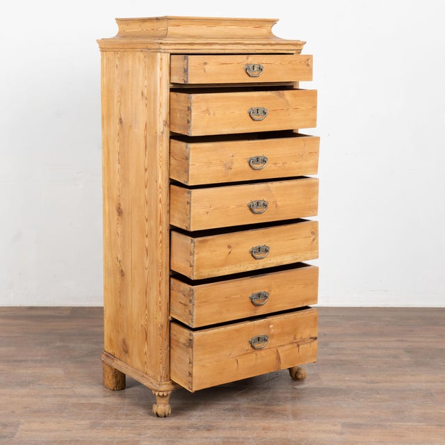 Mid 19th century Danish highboy chest, crafted in pine. This narrow chest features seven drawers and a traditional curved...