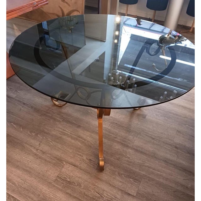 Round table made in the 1950s with a carved brass base and glass top. The actual glass measures 120cm but the base can...