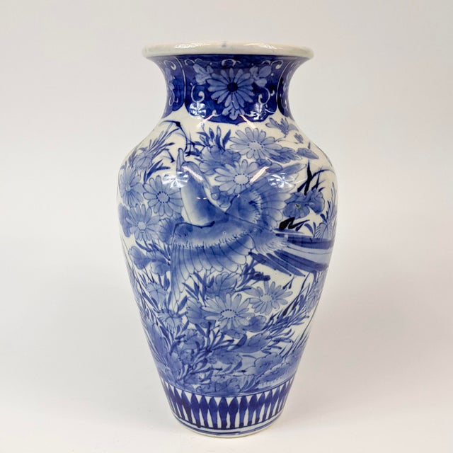 This Blue and white vase has a bird and flower motif that wraps around the entire vase