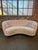 Beautiful Swedish curved sofa in newly upholstered curly ivory fabric. The rounded back and gently curved seat create an...