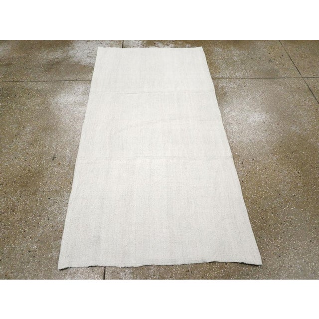 A vintage Turkish flatweave Kilim throw rug handmade during the mid-20th century in white. Measures: 3' 0" x 5' 11"