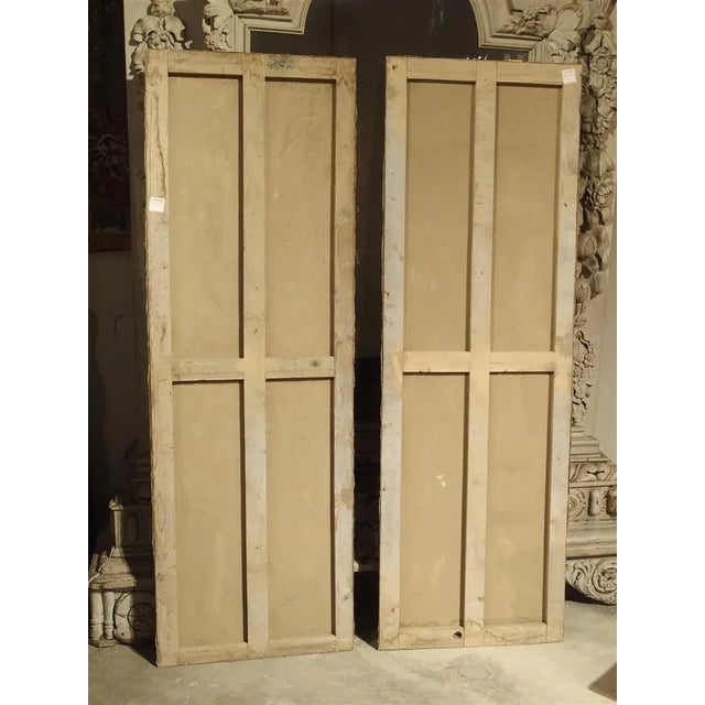 From Italy, this pair of still life paintings depict fruit and vegetables beneath an urn flowing down and over a bench....