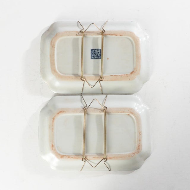 Pair of Chinese blue and white porcelain plates with metal plate hangers on the back. Intricate detailed design.