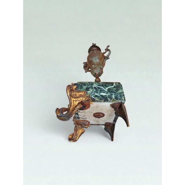 A richly detailed antique french bronze baluster vase with sculptural handles and a lidded finial, raised on a dramatic...