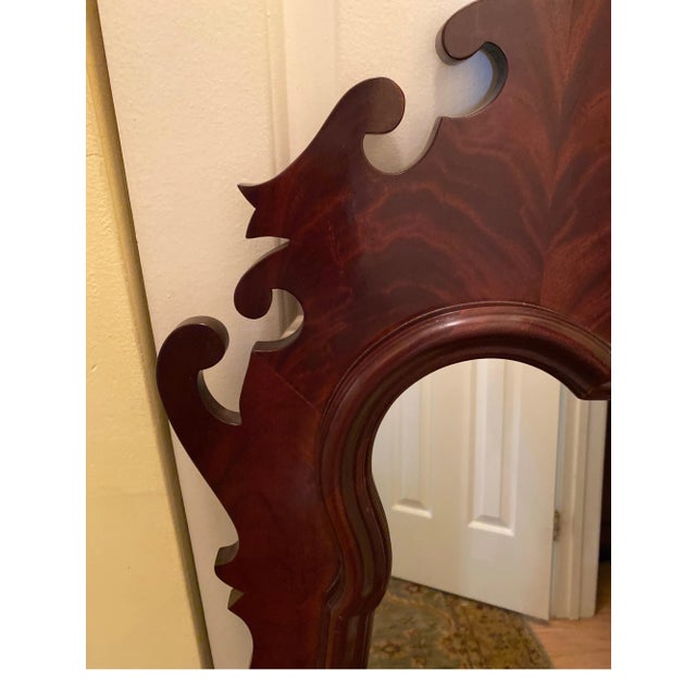Elegant flame mahogany beveled mirror with Chippendale frame. The shapely molding around the beveled glass. The Swirly...