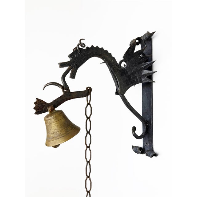 Unique vintage Italian wall-mounted manual bell featuring a hand-forged wrought iron dragon and a brass bell The...