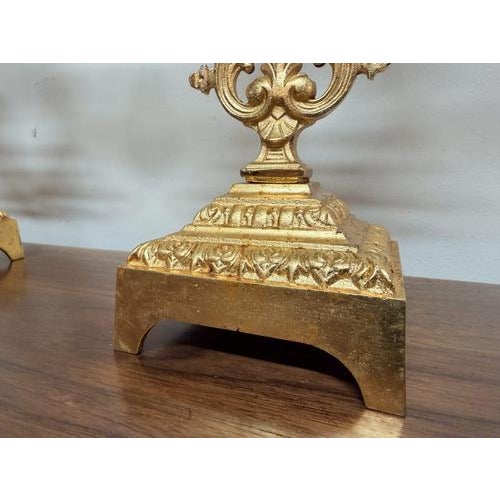 A pair of gilt-brass 20th century candelabras featuring three candle sconces set on elegant scrolling arms, reminiscent of...