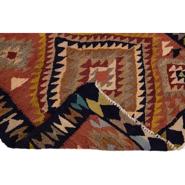 Beautiful vintage Turkish Kilim hand-knotted wool rug with a rust field. This piece has a black frame and multicolor...