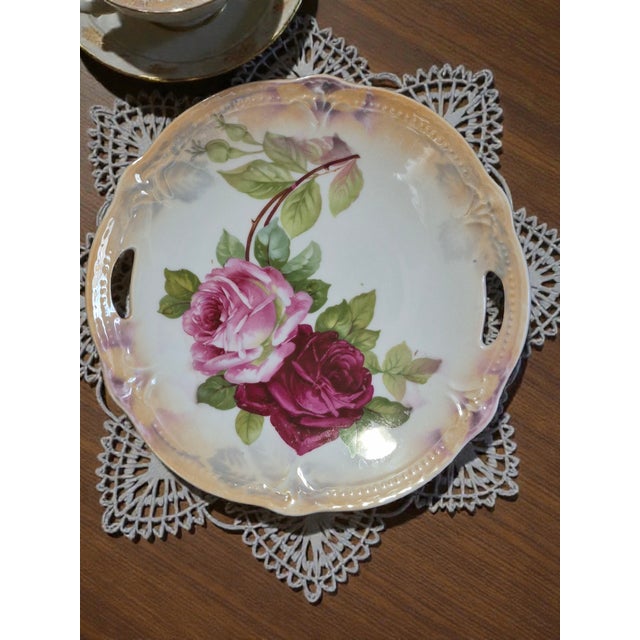 This vintage serving platter from Germany features a romantic floral pattern depicting roses, with luster edges and...