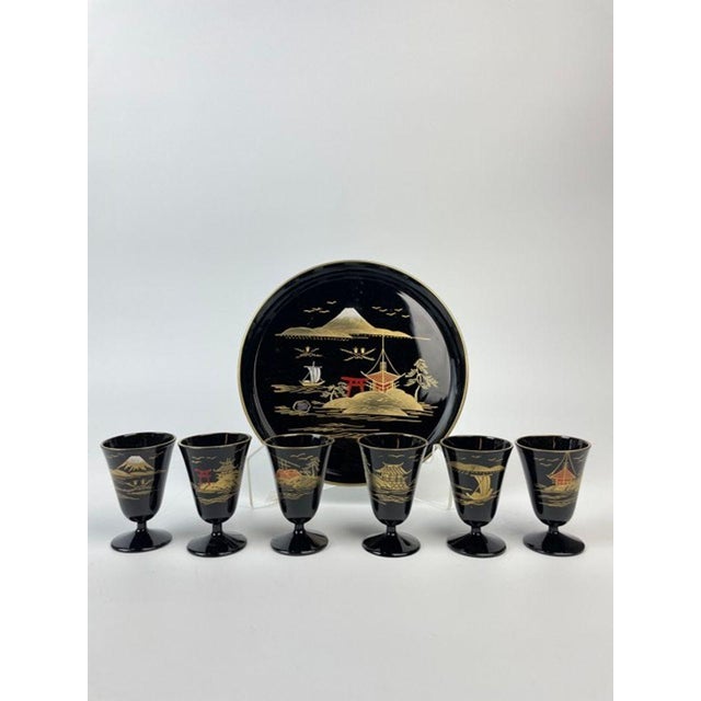 A wonderfully decorative vintage Japanese black lacquerware drinking service comprising six petite stemmed cups, a...
