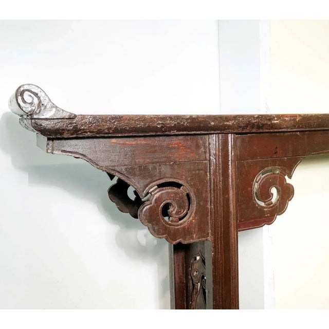 This antique Chinese altar table is handcrafted with elmwood. The traditional Chinese design motif is nicely carved on the...
