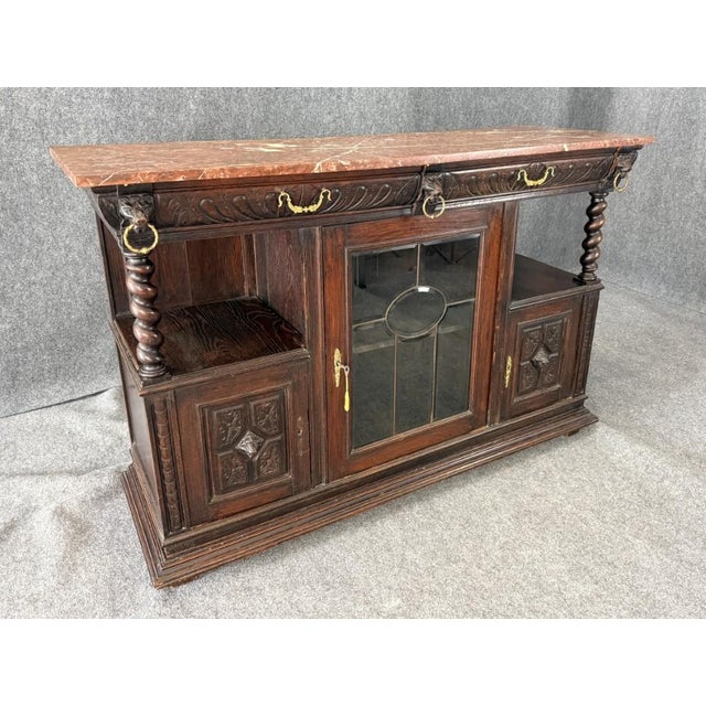 This 19th Century Continental oak buffet features a richly carved case with barley-twist supports, decorative brass...