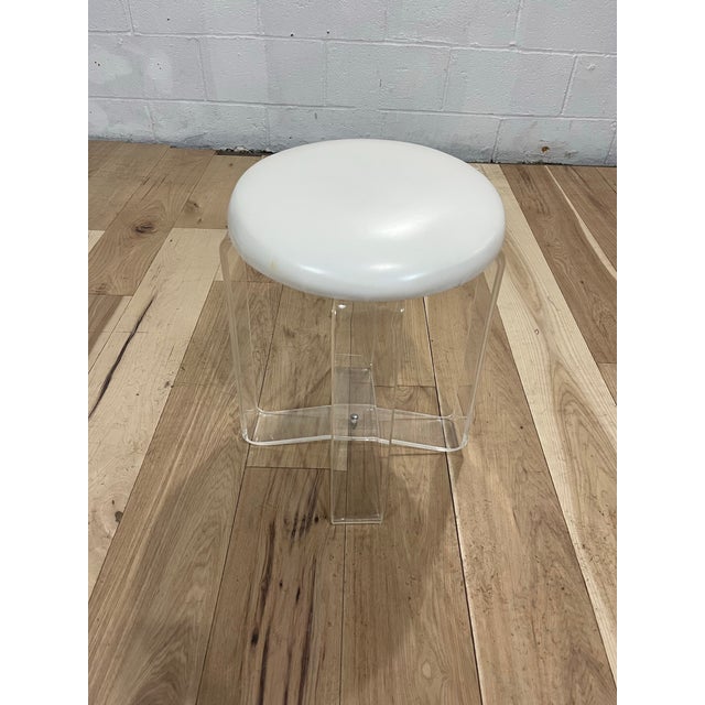Classic mid century lucite vanity stool with vinyl seat cushion. Criss Cross Ribbon design with 2 bands crossing in...