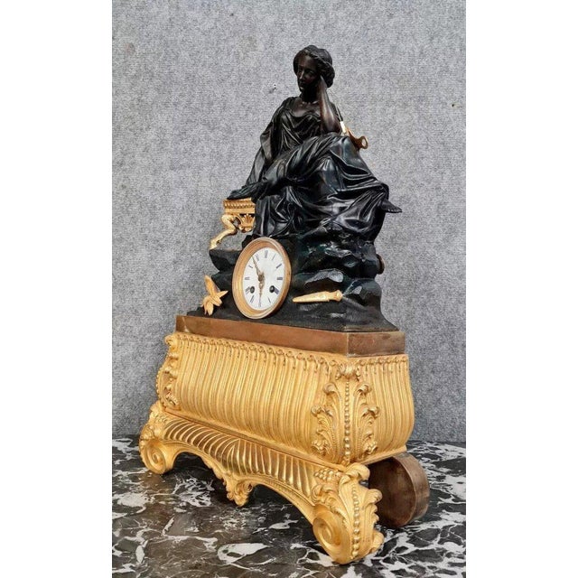 A very important Empire clock, composed of a sculpted group in patinated dark brown and gilt bronze, depicting a seated...
