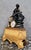 A very important Empire clock, composed of a sculpted group in patinated dark brown and gilt bronze, depicting a seated...