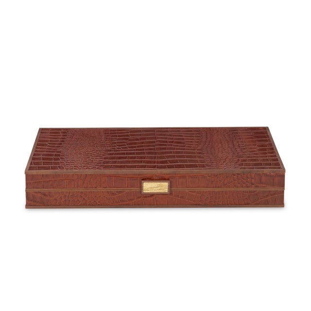 Warm chestnut brown croc leather backgammon game board with walnut trim and a cast brass handle. Interior is crafted of...