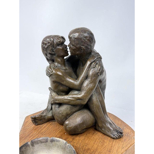 Beautiful bronze sculpture depicting a couple in love, with an ashtray and a solid wood base. A great decorative piece.