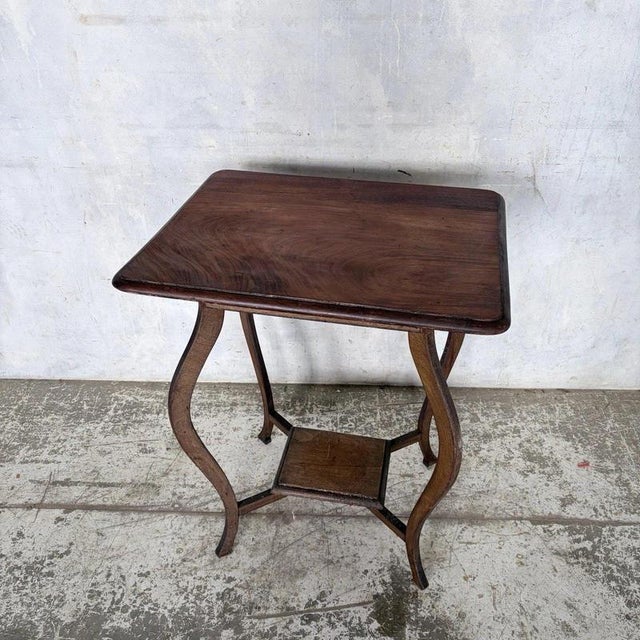 An elegant British Arts and Crafts occasional table in walnut, with Art Nouveau influence and a useful single drawer. Its...