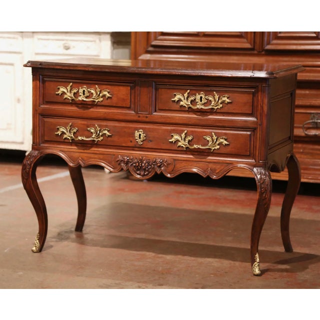 This elegant antique "Commode Sauteuse" was crafted in southern France, circa 1780. The fruitwood chest stands on cabriole...