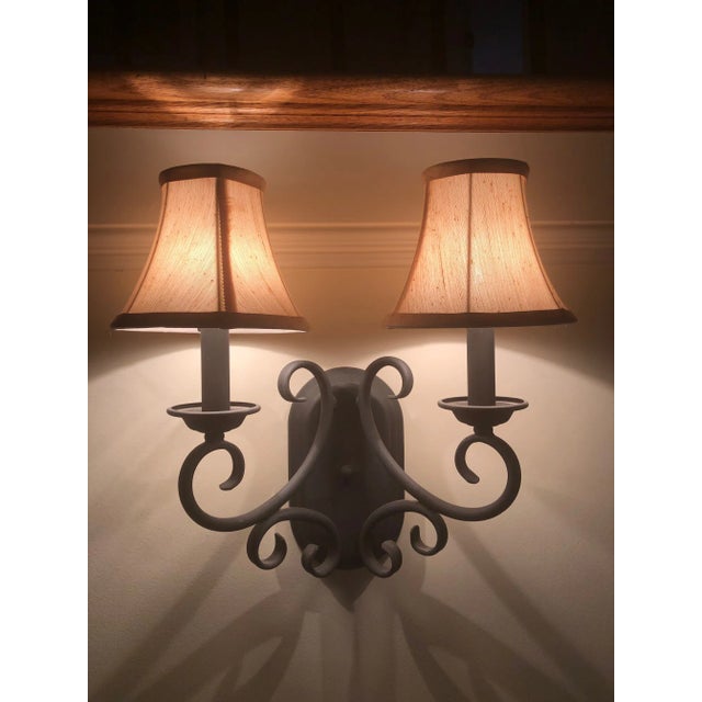 2-light black wrought iron wall sconce with silk shades. Tuscan style curves on this lovely wall sconce. Silk shades...