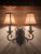 2-light black wrought iron wall sconce with silk shades. Tuscan style curves on this lovely wall sconce. Silk shades...