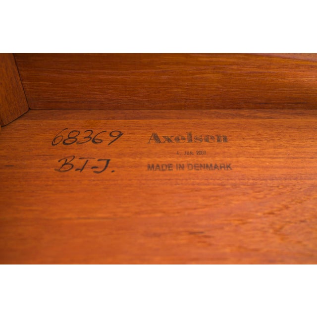Elegant Danish round side table crafted from solid teak and signed by Axelsen (2003). Featuring a sculptural pedestal base...