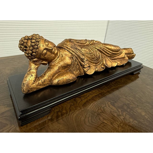 Design Plus Gallery presents a Golden Buddha in Reclining Position. The statue is crafted of wood with intricate hand-...
