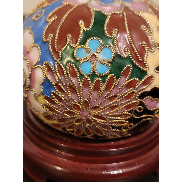 Early 20th century, round enamel paper weight with wood stand. Decorated decorated with colorful lotus, scroll flourishes,...