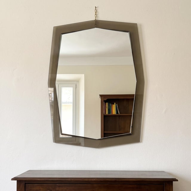 A striking and prestigious double-tiered shaped wall mirror with a smoked glass perimeter frame and a central beveled...
