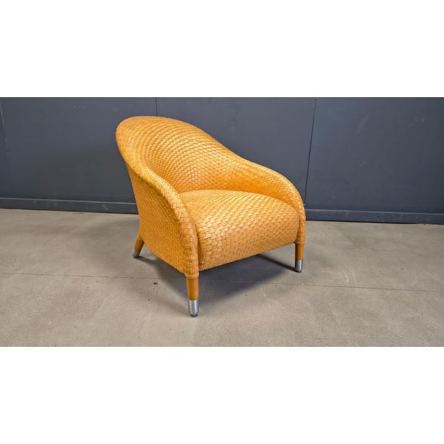 Timeless design armchair crafted from braided leather with wooden and metal legs. Designed by Antonio Citterio and...