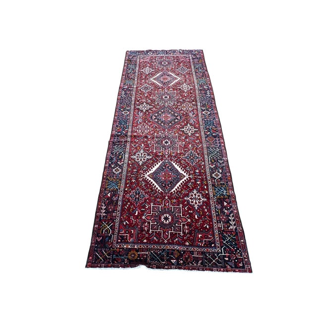 Vintage Persian Karajeh runner, hand knotted in Iran from 100% wool. Measuring 5’ x 12’1”, this rug features a traditional...