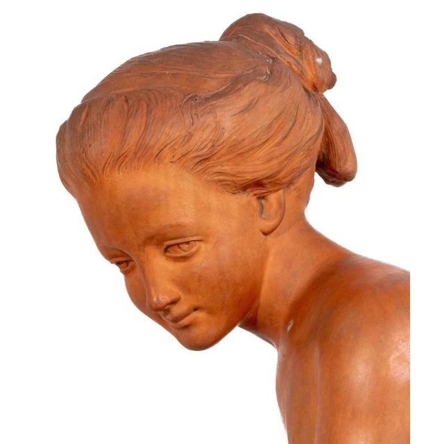 French Terracotta Sculpture of a Seated Child, late 19th century or early 2th century, depicted seated on a rocky outcrop....