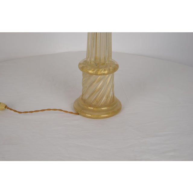 Gold-colored Murano glass table lamp, made in Italy in the 1960s, attributed to Tommaso Barbi. Elegant and slender, it...