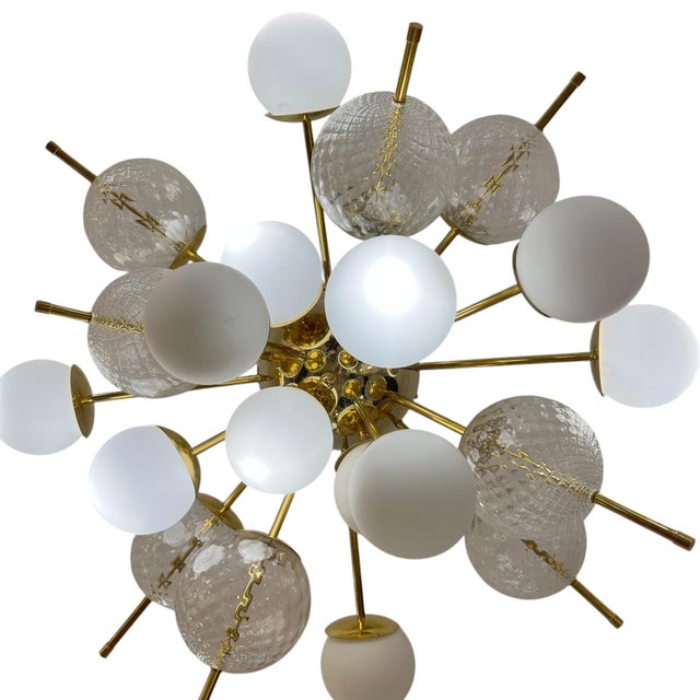 The structure is made of gilded brass with a central gilded globe, from which tubular gilded brass arms extend,...