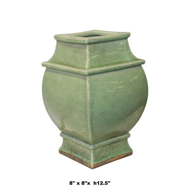 This is a handmade ceramic pottery vase with a square shape curve body design. The surface is glazed with celadon green...