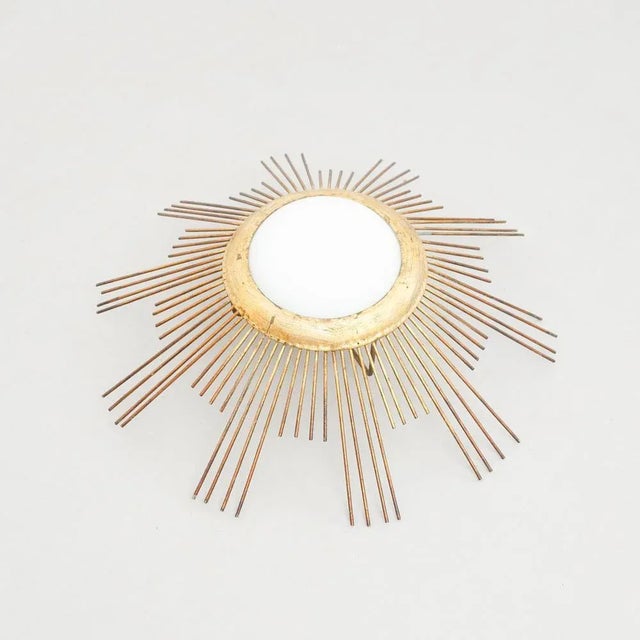 Mid-Century Modern sunburst brass pendant lamp, circa 1960. Traditionally manufactured in France. By unknown designer. In...