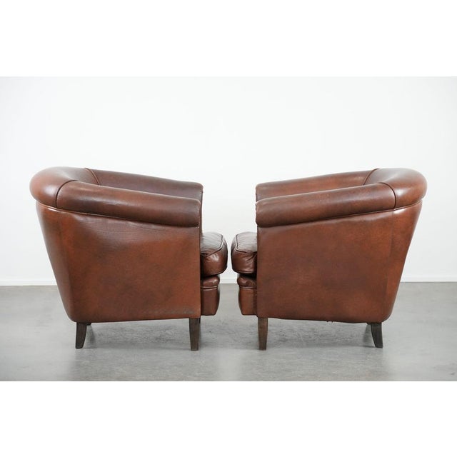 We are offering this unique set of two cognac-colored cowhide club chairs in English style with a luxurious look. This...