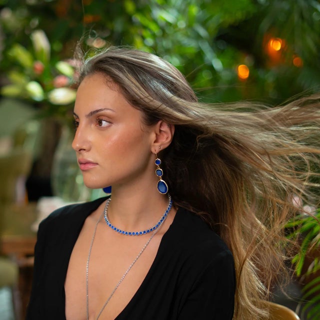 Add a touch of timeless elegance and mystical charm with the Blue Cat Eye Dangle Earrings. Featuring luminous blue cat eye...