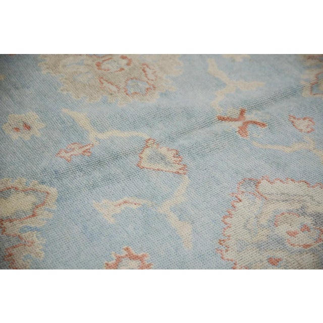 This modern Turkish Oushak rug is a stunning piece of art that has been handwoven using traditional techniques by skilled...