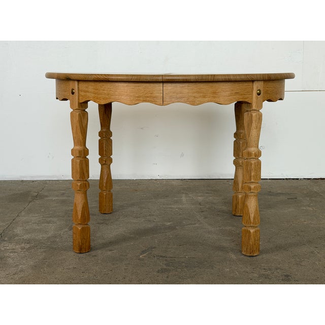 A solid oak round extending dining table by an anonymous Danish cabinetmaker, Denmark, 1970s. The table converts from...