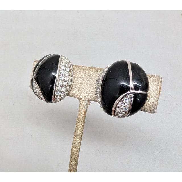 1980s round rhodium plated black enamel and pavé Round clear rhinestone clip earrings. Marked with the Courreges symbol on...